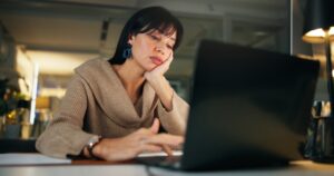 depressione-da-lavoro-donna-lavoratrice-che-guarda-pc-con-sguardo-triste-e-annoiato